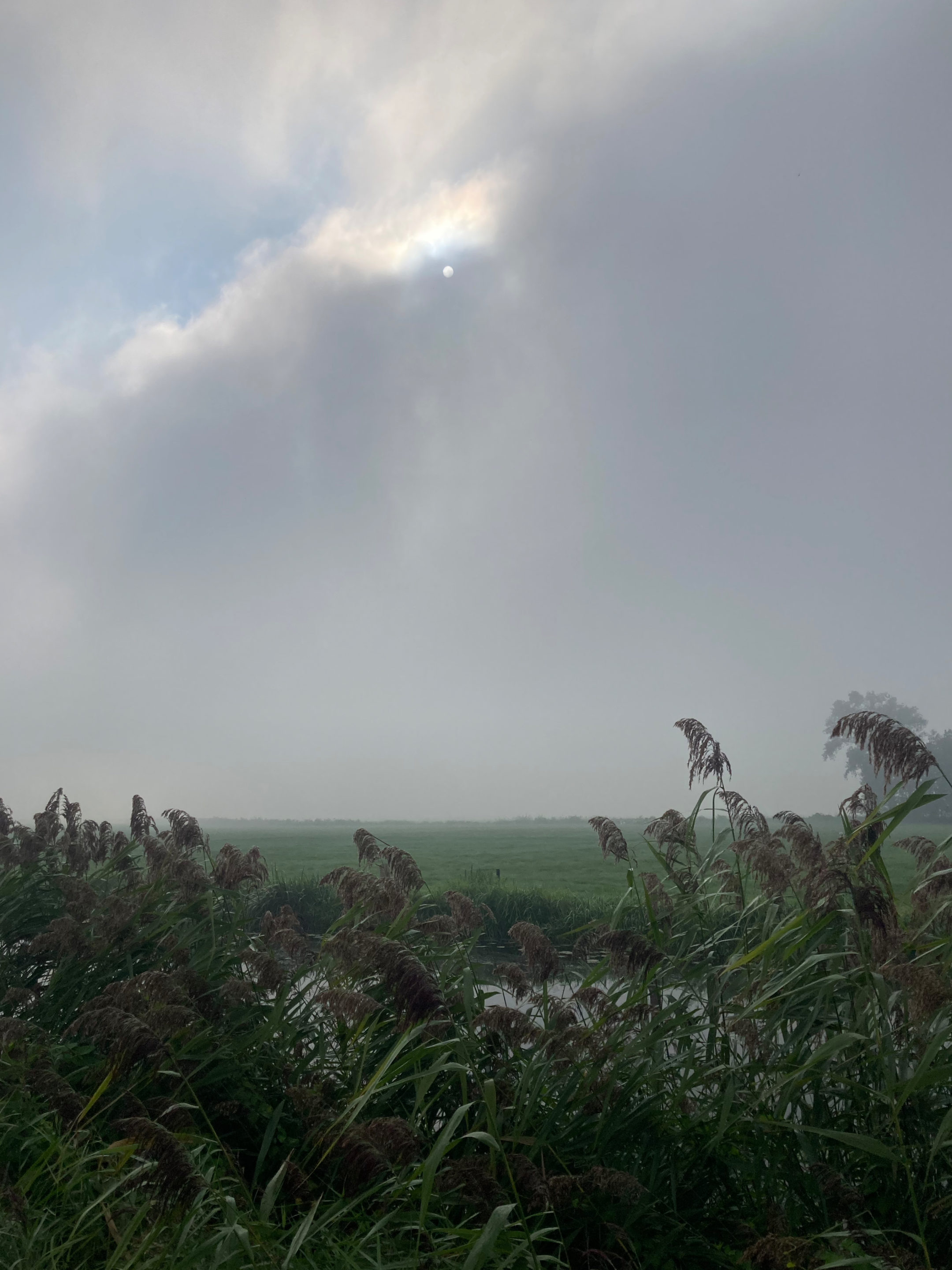 The sun hiding behind the clouds between Mastenbroek and Hasselt.